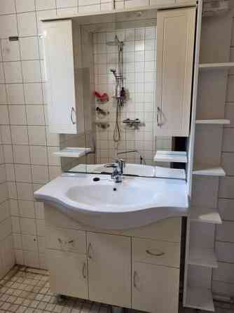 Kylpyhuoneen allaskaappi altaalla ja peili sivukaapeilla. Porvoo