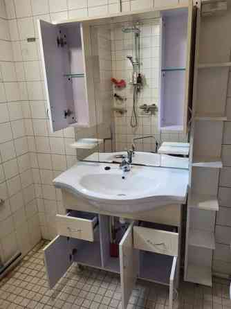 Kylpyhuoneen allaskaappi altaalla ja peili sivukaapeilla. Porvoo